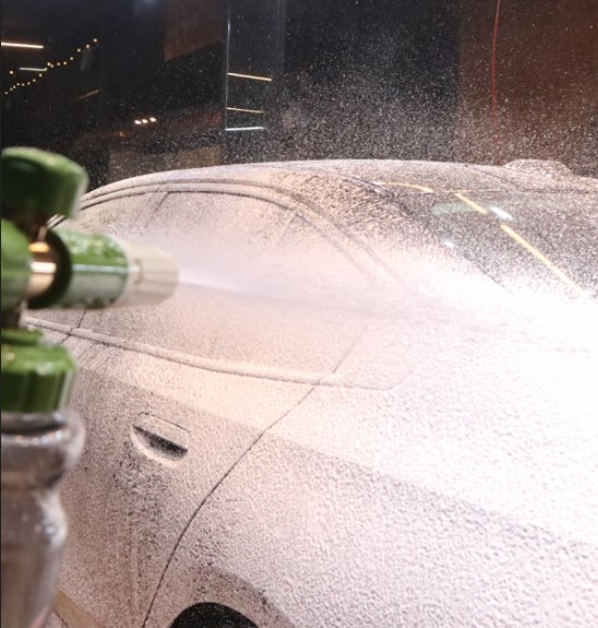 Neutral snow foam being applied evenly to vehicle paint with a foam cannon