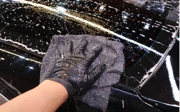 Soft long-pile microfiber towel used on a foamed car panel during contact washing